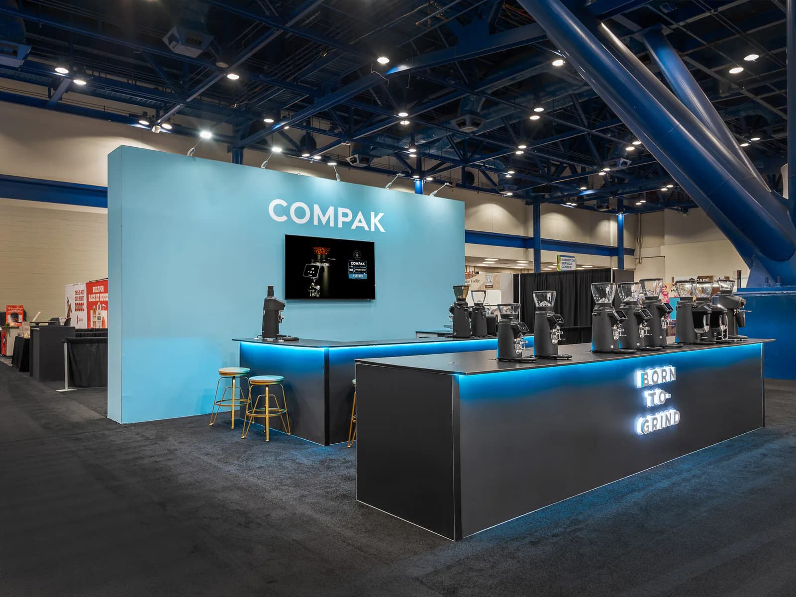 Blue-and-black hospitality exhibit with a long illuminated service counter.