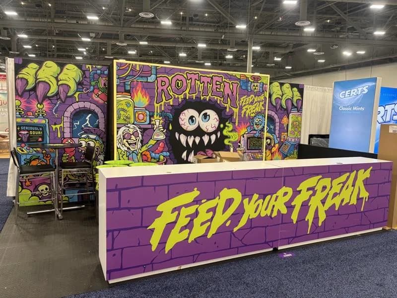 Vivid graphic exhibit with a broad purple counter and colorful wall art.